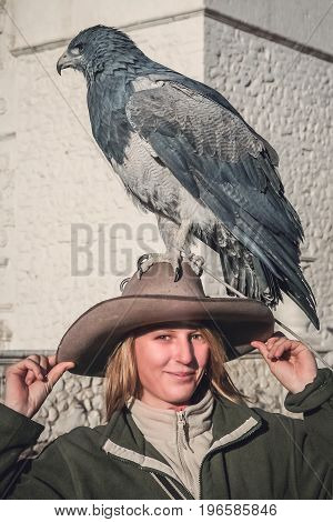 Female tourists with a native to the Andes eagle sitting calmly on her hat in the Colca Canyon in Peru, South America