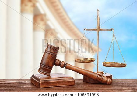 Judge's gavel with scales and courthouse on background. Concept of law