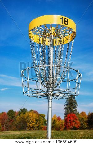Disc golf target against blue sky in autumn