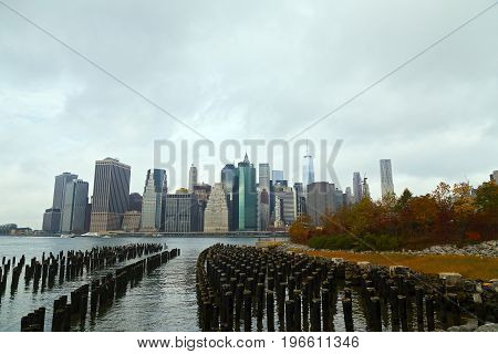 Lower Manhattan panorama on a cloudy morning in autumn New York USA. Distant view of New York landmarks and park in fall bright colors.