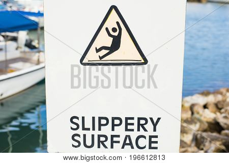 Warning: Slippery Surface sign near the sea