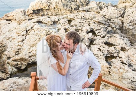Bride and groom on a romantic moment near the sea.