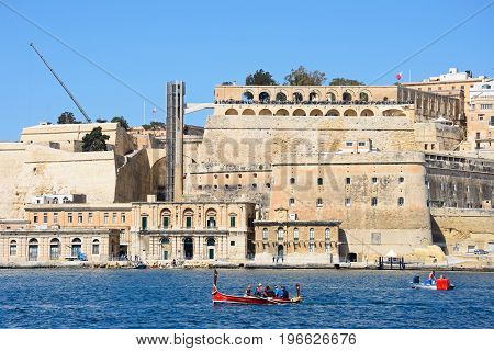 VALLETTA, MALTA - MARCH 31, 2017 - Tourists aboard a traditional Maltese Dghajsa water taxi with views towards Upper Barraka Gardens Valletta Malta Europe, March 31, 2017.