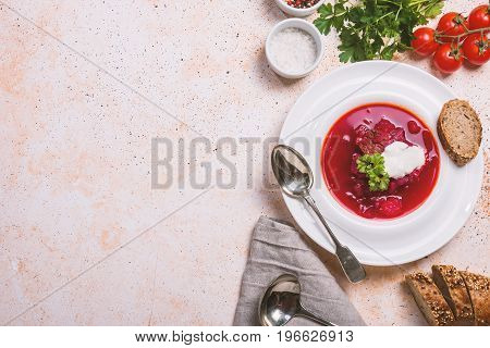 Homemade Russian, Ukrainian and Polish national soup - red borscht made of beetrot, vegetables and meat with sour cream Top view.