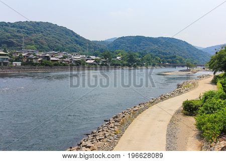 View of Uji river with the Uji Bridge houses mountain and blue sky in summer at Uji city near Kyoto Japan.