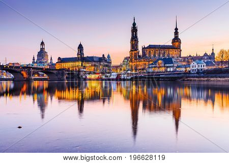 Dresden Germany. Cathedral of the Holy Trinity or Hofkirche Bruehl's Terrace. Twilight sunset on Elbe river in Saxony.