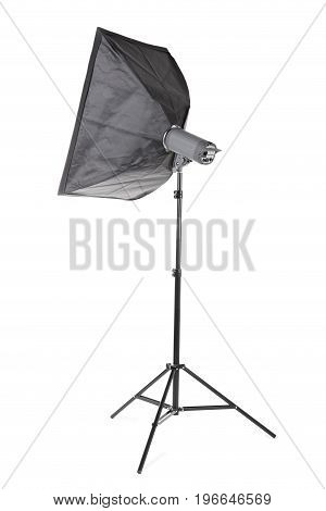 A modern gray softbox isolated over the white background. Professional electric equipment for photographers. A lighting stripbox with a flashlight on a tall tripod. Photographic accessory.