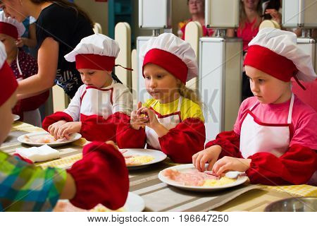 Alchevsk, Ukraine - July 23, 2017: School Cook For Children. Meat Rolls With Cheese Are Prepared.