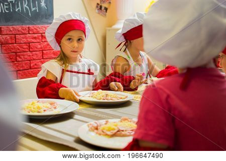 Alchevsk, Ukraine - July 23, 2017: School Cook For Children. Meat Rolls With Cheese Are Prepared.