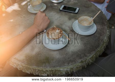 Cup coffee and phone on the table in coffee shop at morning  .