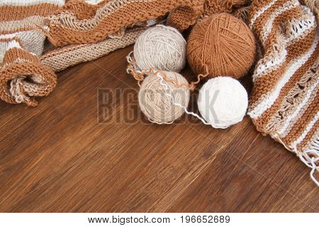 Balls of wool and knitting on the wooden background
