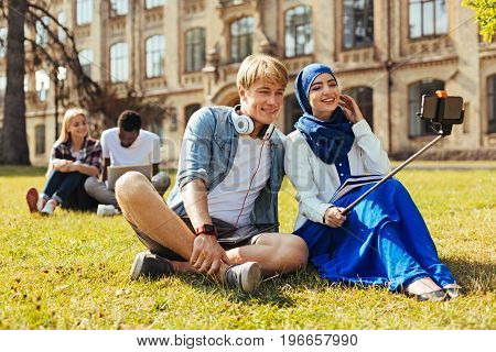 Smile with me. Two progressive motivated cool students meeting after classes and enjoying their time together while memorizing the moment using camera