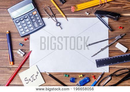 Album sheet with copyspace and student material on wooden table. Top view