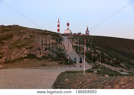 Couple of hikers walking on a mountain at sunset in Navacerrada Madrid. Spain