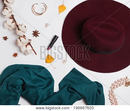 Hat, skarf and small autumn related items on white background
