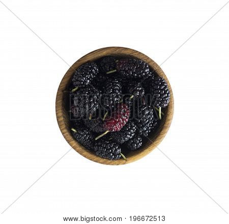 Mulberries in a wooden bowl with copy space for text. Top view. Ripe and tasty mulberry isolated on white background.