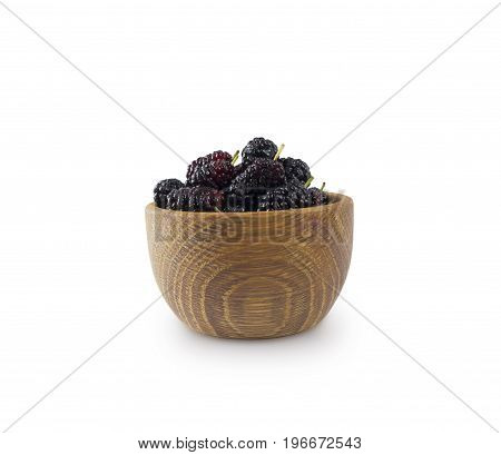 Mulberries in a wooden bowl with copy space for text. Ripe and tasty mulberry isolated on white background.