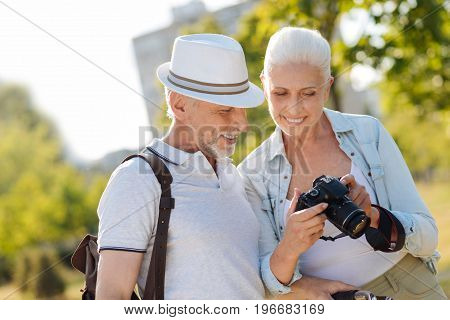 Let me choose. Handsome man wearing stylish hat and keeping backpack on right shoulder while looking at camera
