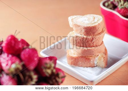 Cake in bowl with strawberry on the table.