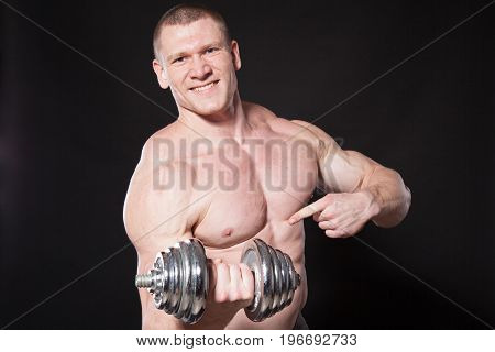 Sport the athlete bodybuilder shakes their muscles dumbbells