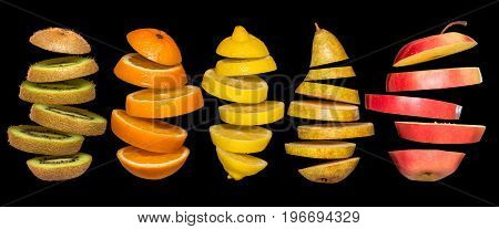 Creative concept with food. Set of sliced fruits isolated on black background. Flying lemon, orange, kiwi, pear, apple. Levity fruit floating in the air