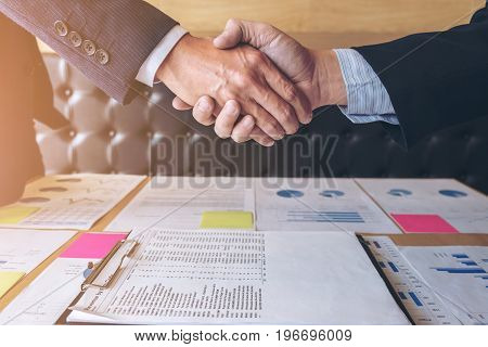 Successful business handshake Two confident business colleagues briefing and discussing ideas of project about company offer in the office and shaking hands during a meeting success dealing happy.