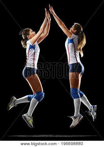 Female professional volleyball players isolated on black background