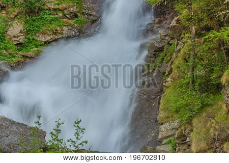 an imposing waterfall falls impetuous from the glaciers in the National Park of Great Paradisein Piedmont ,Italy