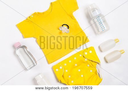 Baby clothes and accessories on white background. Top view. Copy space. Still life. Flat lay