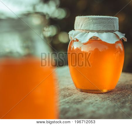 Two cans of natural honey. Honey on the fabric.