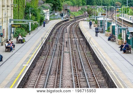 West Brompton Underground Station Platforms, With Commuters Waiting On Platforms