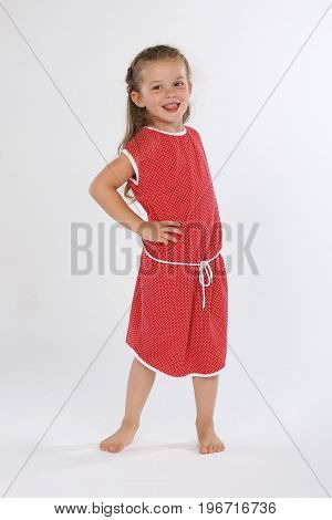 Cute little girl bare feet with red dress smiling