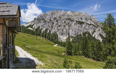 Old stone hut with mountain Gartnerkofel in the background on Nassfeld in Carnic Alps in Austria