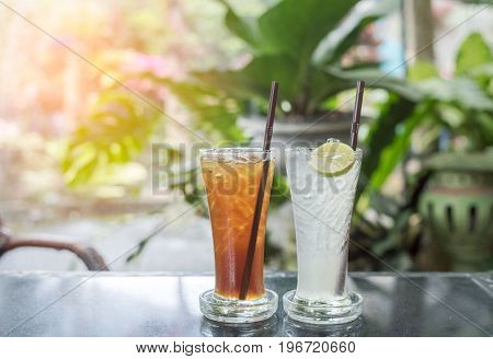 Fresh cold water with lemon and ice in a pitcher on the table