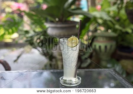 Fresh cold water with lemon and ice in a pitcher on the table