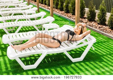 Woman Relaxing In Chaise Lounge At The Poolside. Summer Relax