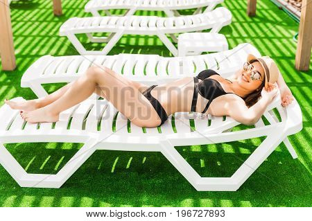 Woman Relaxing In Chaise Lounge At The Poolside. Summer Relax