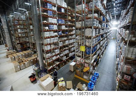 Wide angle shot of warehouse interior with rows of shelves and racks