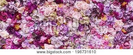 Flower texture background for wedding scene. Roses, peonies and hydrangeas, artificial flowers on the wall. Banner for website.