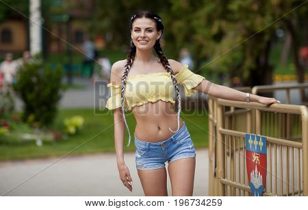 Portrait of a sexy brunette woman with a modern pigtail. She has long black hair and well-groomed skin.