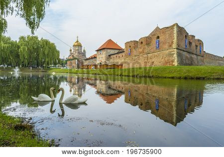 Fagaras Fortress - June 4: Fagaras fortress in the middle of the lake near the cathedral under renovation in Fagaras Brasov county Romania.