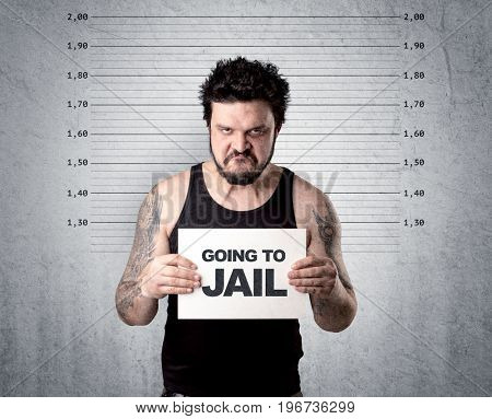 Caugth offender in front of a wall with table in his hand.