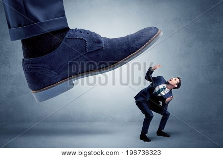 Big foot trying to crush small man who is afraid of that