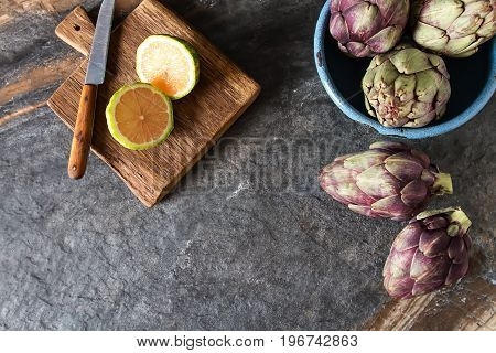 Baby Ripping Organic Artichokes With Lemon. Food For A Vegan And