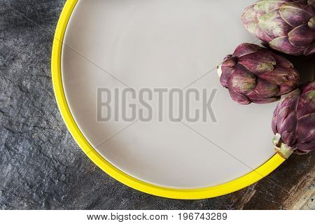 Baby Ripping Organic Artichokes With Lemon. Food For A Vegan And