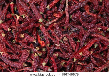 Pile of dried red chili peppers background, top view.
