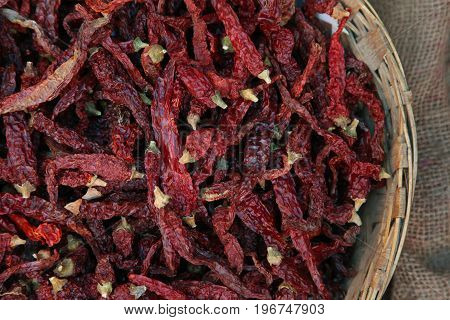 Pile of dried red chili peppers background, top view.