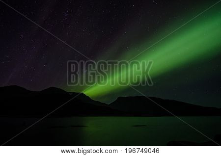 Northern lights at night over a lake in Igaliko Greenland