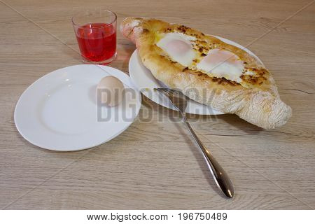 Adjarian khachapuri close-up. This traditional georgian dish contains brinsen cheese butter and row egg. Delicious homemade khachapuri in Adjarian