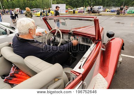 Orel Russia July 22 2017: Dynamica car festival. Senior man sitting in red Fiat cabriolet closeup